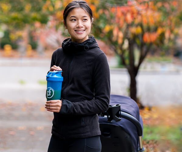 Parent/ Mother drinking zipfizz on her walk with her stroller.